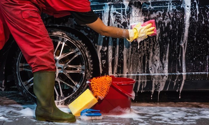 A car body being washed by hand.