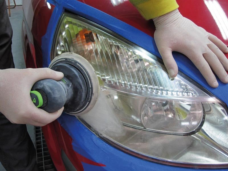 A car headlight being polished.