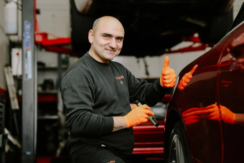 One of the owners of Lexauto Madrid beside a car in the garage.